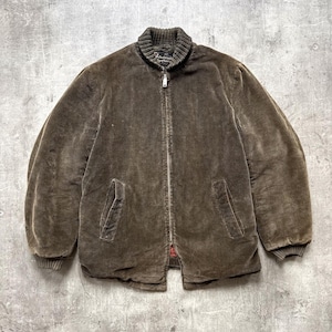May include: A brown corduroy zip-up jacket featuring a ribbed stand-up collar, long sleeves with ribbed cuffs, and two front slash pockets. The jacket has a central metal zip closure and a visible interior label at the neckline.