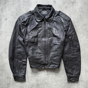 Peut inclure: Veste en cuir noir avec fermeture éclair, col et plusieurs poches. La veste a un aspect vintage avec des signes d'usure. L'étiquette sur le col indique "BABYLON 40-R".
