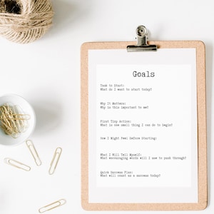 May include: A white clipboard with a cork border and a silver clip holds a sheet of paper with the word "Goals" at the top. The paper lists questions to help set goals, including "Task to Start", "Why It Matters", "First Tiny Action", "How I Might Feel Before Starting", "What I Will Tell Myself", and "Quick Success Plan".