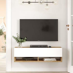May include: A modern wall-mounted TV stand with a white cabinet and a natural wood-tone frame. A black TV is mounted above the stand. A DVD player, remote, and decorative items are on the stand. A glass vase with greenery is on the stand.