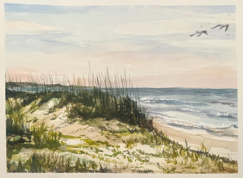 May include: Watercolor painting of a beach scene with sand dunes, tall grass, and the ocean under a pastel sky. Two birds are flying in the distance. The artwork uses soft colors and brushstrokes to depict a serene coastal landscape.