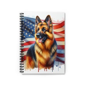 May include: A spiral-bound notebook with a watercolour illustration of a German Shepherd dog set against an American flag. The design features the dog in shades of black, brown, and gold, with the flag's red, white, and blue colours. Ideal for notes and sketches.