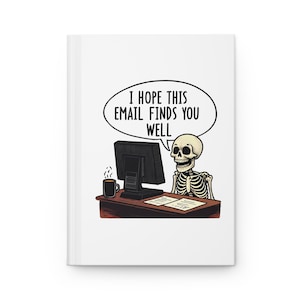 May include: White journal with a humorous illustration of a skeleton at a desk. The skeleton is sitting in front of a computer, with a coffee mug and the text "I HOPE THIS EMAIL FINDS YOU WELL" in a speech bubble.