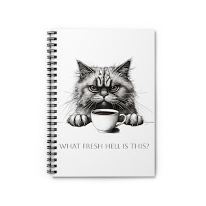 Peut inclure: Cahier à spirales blanc avec une illustration en noir et blanc d'un chat grincheux regardant une tasse de café. Le texte "WHAT FRESH HELL IS THIS?" est imprimé en dessous. Le chat a l'air furieux.
