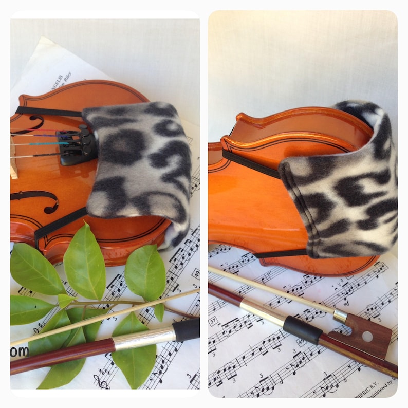 Puede incluir: Un viol&iacute;n con un reposabrazos de patr&oacute;n blanco y negro y un arco de viol&iacute;n marr&oacute;n sobre partituras.