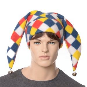 May include: A colorful jester hat with red, yellow, blue, and white diamond patterns. The hat has two long, pointed ears with bells at the ends.