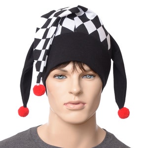 May include: A black and white checkered jester hat with red pom-poms on the ends of the long black ear-like flaps.
