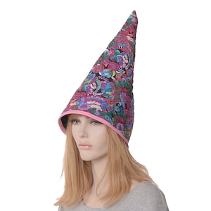 May include: A tall, pointed hat with a pink trim and a colorful floral pattern. The hat is made of fabric and has a conical shape.