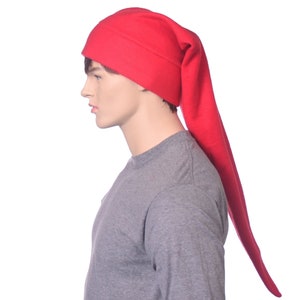 May include: A vibrant red hat with a long, pointed tip. The hat is made of a soft fabric and is worn by a mannequin. The hat is a solid colour and has a simple design. The hat is a type of sleep cap or novelty hat.
