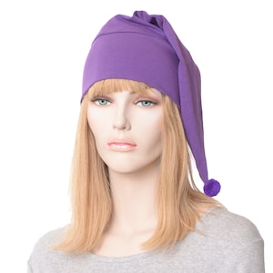 May include: Purple sleep cap with a long pointed flap and a pom pom at the end. The cap is made of soft fabric and is designed to keep hair out of the face while sleeping.