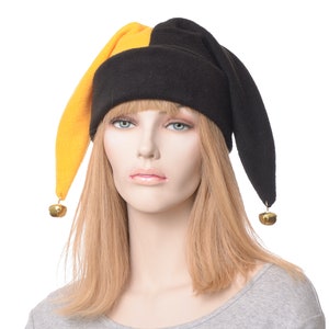 May include: A black and yellow jester hat with gold bells on the ends of the points. The hat is made of fleece and has a pointed crown.