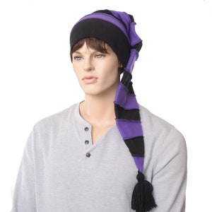 May include: A black and purple striped hat with a long tail and a tassel. The hat is worn by a mannequin. The hat's design features alternating black and purple stripes, with a solid black band at the base and a black tassel at the end of the tail.