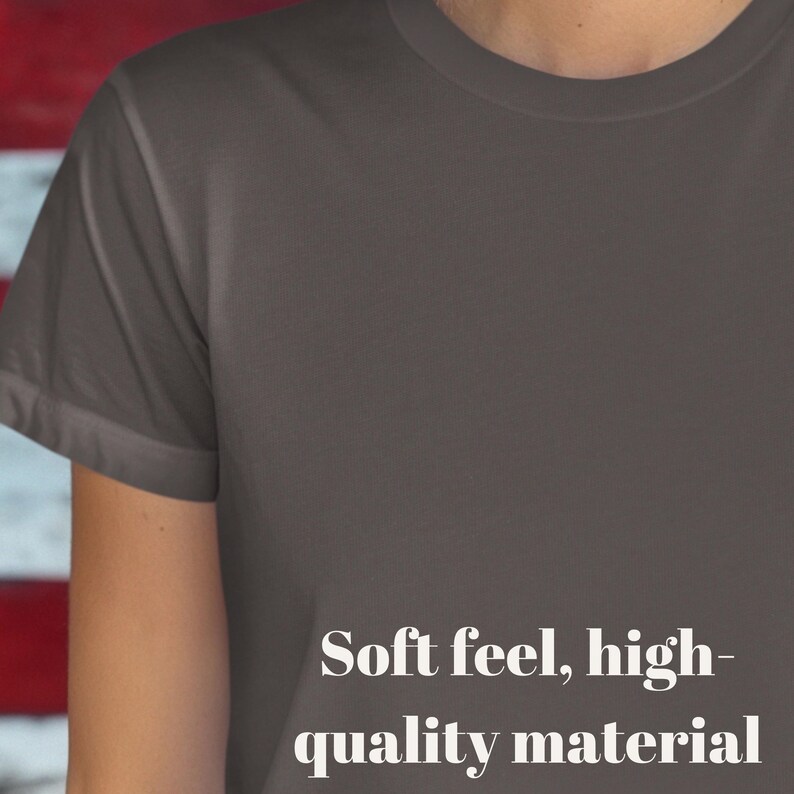 K&ouml;nnte beinhalten: Nahaufnahme eines dunkelgrauen T-Shirts. Das Shirt hat kurze &Auml;rmel und einen Rundhalsausschnitt. Der Text "Soft feel, high-quality material" ist in Wei&szlig; auf dem unteren Teil des Shirts aufgedruckt.