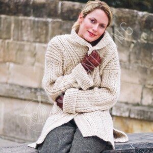 Peut inclure: Un cardigan en tricot torsadé de couleur crème doté d'un col montant, de manches longues à larges poignets et d'un motif texturé de tresses verticales. Le vêtement est porté sur un pantalon gris foncé avec des gants en cuir marron foncé.