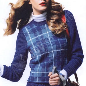 Könnte beinhalten: Blauer Argyle-Pullover mit weißem Rollkragen. Der Pullover hat ein klassisches Argyle-Muster in Blau- und Weißtönen. Die Ärmel sind einfarbig blau. Die Person hält einen Skistock und trägt eine Uhr.