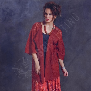 May include: A red knitted cardigan with open front and three-quarter sleeves. The cardigan has a textured pattern on the sleeves and a flowing design. The model is wearing a blue top and a floral skirt, with a beaded necklace.