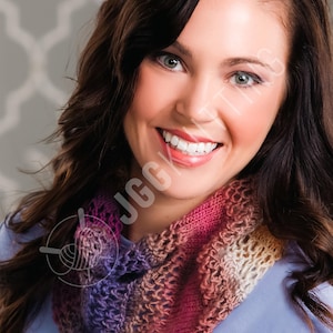 Könnte beinhalten: Ein farbenfrohes, handgestricktes Cowl in Rosa-, Lila- und Beigetönen. Das Cowl wird um den Hals getragen und hat ein offenes, durchbrochenes Design. Die Frau im Bild lächelt und trägt ein hellblaues Hemd.