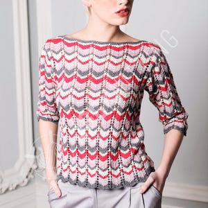 May include: A knitted sweater with a boat neck and three-quarter sleeves. The sweater features a chevron pattern in shades of red, pink, gray, and white. The cuffs and neckline are trimmed in gray.