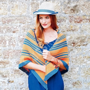 May include: A triangular knit shawl featuring horizontal stripes in orange and dark blue, worn over a solid dark blue garment. The shawl has a dark blue border and is paired with a straw fedora hat that has a matching dark blue ribbon band.