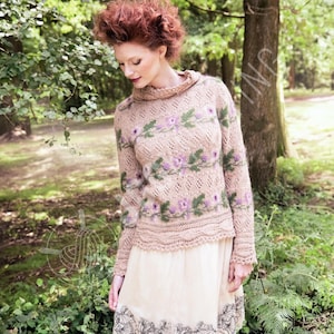 Peut inclure: Un pull beige orné d'un motif floral violet et vert. Le pull a des manches longues et un col montant côtelé. Le modèle porte une jupe crème avec un motif floral noir sur l'ourlet. La scène se déroule en extérieur, entourée d'arbres.