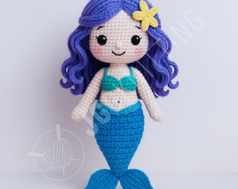 Puede incluir: Muñeca de sirena de ganchillo hecha a mano con cabello azul y una flor amarilla. La muñeca tiene un top de bikini turquesa y una cola azul. La muñeca está hecha de hilo y tiene una cara sonriente.