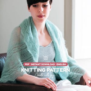 Puede incluir: Un chal tejido de color verde menta claro con un delicado patrón de encaje. La imagen incluye el texto: PDF INSTANT DOWNLOAD ENGLISH KNITTING PATTERN Create with joy. El chal está colocado sobre los hombros, mostrando su textura calada.