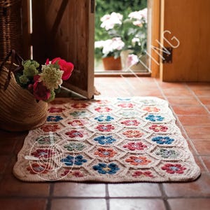 May include: A rectangular, off-white crochet rug with a floral pattern in red, blue, orange, and green. The rug is placed on a terracotta tile floor near an open wooden door and a woven basket with flowers.