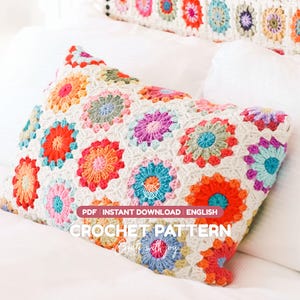 Könnte beinhalten: Ein rechteckiger Kissenbezug aus Häkelarbeit mit einem mehrfarbigen Granny-Square-Motiv mit kreisförmigen Zentren in Orange, Rot, Blau, Pink und Grün, verbunden mit weißem Garn. Der Text lautet: PDF INSTANT DOWNLOAD ENGLISH CROCHET PATTERN.