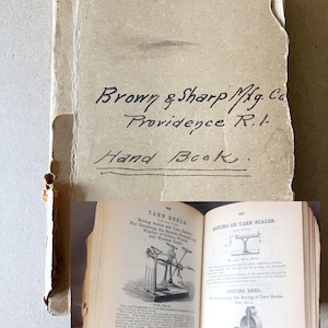 May include: An open vintage handbook with the title "Brown & Sharp Mfg. Co. Providence R.I. Hand Book." The pages show illustrations and text about yarn reels and scales. The cover is a faded tan color.
