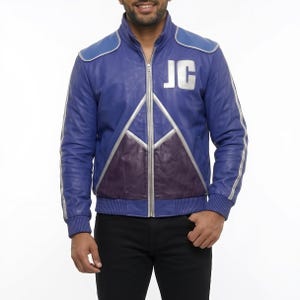 May include: A blue leather jacket with silver accents and a purple lower panel. The jacket features a high collar, a zipper closure, and the initials "JC" in silver on the chest. Silver stripes run down the sleeves.