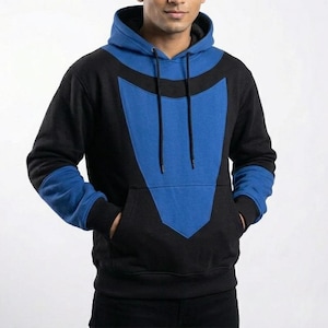May include: Black and blue hooded sweatshirt. The sweatshirt has a large blue panel on the chest and blue accents on the sleeves and hood. It features a front pocket and a drawstring hood. The material appears to be a soft, comfortable fabric.