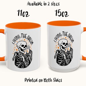 Op de afbeelding: Witte keramische mokken met oranje binnenkant en handvatten. Elke mok heeft een zwart-witte skeletafbeelding met de tekst "LIVING THE DREAM". Verkrijgbaar in 312 ml en 425 ml. Aan beide zijden bedrukt.