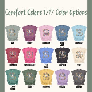 May include: A display of Comfort Colors t-shirts in various colors, including Bay, Berry, Blossom, and Blue Jean. Each shirt features a graphic of a bunny reading books. The text "Comfort Colors 1717 Color Options" is at the top.