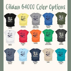 以下が含まれることがあります： Gildan 64000のカラーオプションTシャツのディスプレイ。 黒、白、赤、青など、さまざまな色のシャツがあります。 各シャツには、「I Baked You Some Shut The Fucupcakes」というテキストとともに、カップケーキを持っている女性のグラフィックが描かれています。
