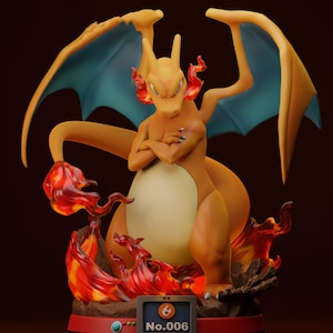 Könnte beinhalten: Eine detaillierte Figur von Glurak, einem Feuer-Pokémon, mit orangefarbenen und gelben Schuppen, blauen Flügeln und Flammen um seine Füße. Die Figur steht auf einem roten Sockel mit einem Pokédex-Bildschirm, auf dem "No. 006" angezeigt wird.