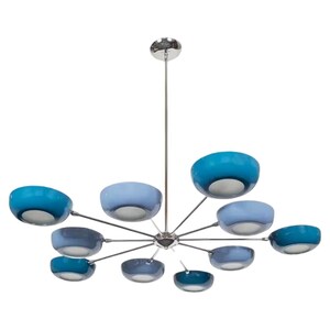 May include: A modern chandelier with a chrome finish and multiple bowl-shaped light fixtures. The lights are in shades of blue, ranging from light to deep turquoise. The fixture is suspended from a single chrome rod.