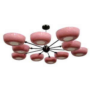 May include: A modern chandelier featuring ten pink, speckled, bowl-shaped shades. The shades are suspended from a central black hub by slender black arms. The light fixtures have white interiors.