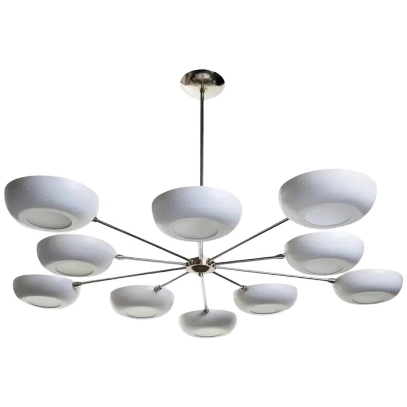 May include: A modern chandelier with a polished chrome finish and ten white, bowl-shaped shades. The shades are evenly spaced around a central hub, creating a starburst design. The fixture is suspended from a single chrome rod.