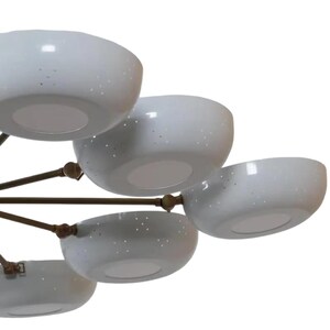 May include: A modern chandelier featuring multiple white, bowl-shaped shades with small perforations. The shades are attached to a bronze-colored frame. The light fixtures are arranged in a multi-tiered design, suitable for home decor.