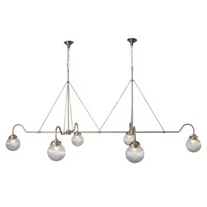 May include: A bronze-toned, multi-light pendant lamp with six globe-shaped, ribbed glass shades. The fixture has a linear design with curved arms and a chain suspension. The overall style is vintage or industrial.