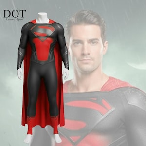 Peut inclure: Un costume de super-héros noir et rouge avec une cape rouge, présenté sur un mannequin. Le costume présente un emblème et des accents de poitrine rouges, avec le texte "DOT Custom Apparel" dans le coin supérieur gauche. L'arrière-plan comprend une image floue d'un homme.