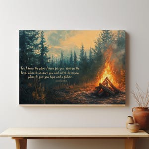 May include: Canvas art print depicting a campfire scene in a forest. The artwork features a warm color palette with a bonfire in the foreground and trees in the background. Text from Jeremiah 29:11 is included.