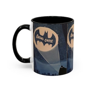 May include: White ceramic mug with a black handle and interior. The mug features a Batman-themed design with the text "Bring Coffee" inside the bat symbol, set against a night sky backdrop with a cityscape silhouette.