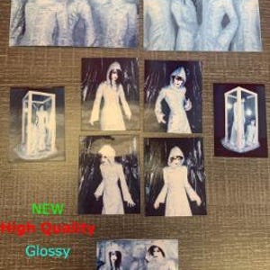 Op de afbeelding: Set van acht glanzende fotokaarten met een band in verschillende poses. De bandleden dragen witte gewaden met kap en staan in een besneeuwde of ijzige omgeving. De foto's zijn van hoge kwaliteit en hebben een vintage uitstraling.