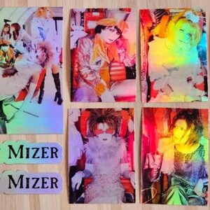 Op de afbeelding: Zes holografische verzamelkaarten met een band genaamd "Mizer". De kaarten zijn rechthoekig en hebben een regenboogkleurige, iriserende afwerking. De bandleden dragen kleurrijke kleding en hebben opvallende kapsels. Twee stickers met de naam van de band zijn ook inbegrepen.