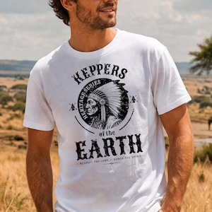 Puede incluir: Camiseta blanca con un gráfico negro de un jefe nativo americano con un tocado. El gráfico está rodeado de texto que dice "KEPPERS HERITAGE SERIES OF THE EARTH". La camiseta también incluye las frases "RESPECT THE LAND" y "HONOR THE SPIRIT".