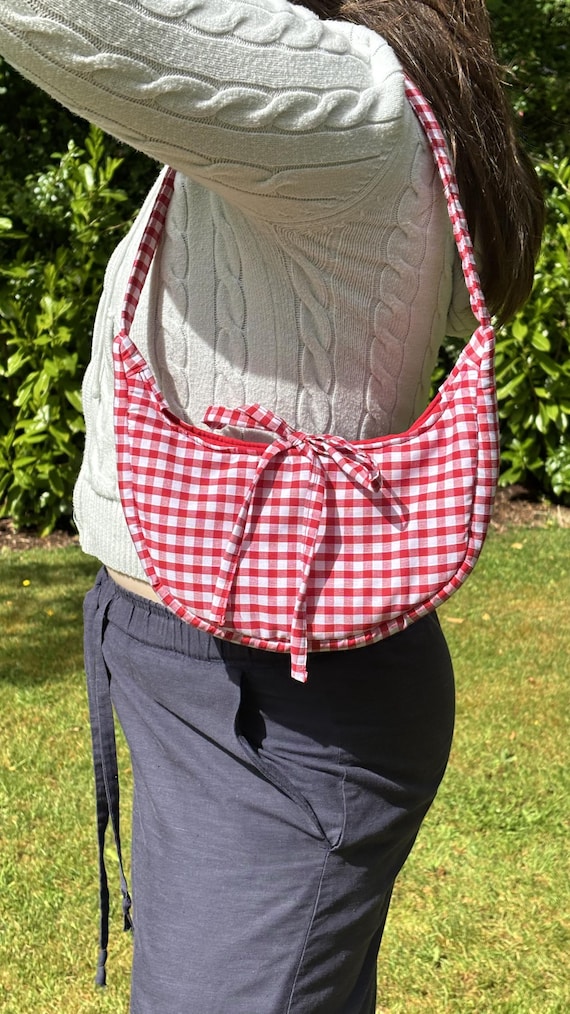 Handmade, red gingham shoulder bag with bow fastening.