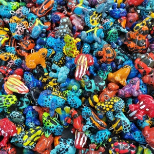 Puede incluir: Una colecci&oacute;n de figuritas de ranas coloridas, cada una con un dise&ntilde;o y un patr&oacute;n &uacute;nicos. Las ranas est&aacute;n hechas de una variedad de materiales, incluyendo cer&aacute;mica, vidrio y madera. Todas est&aacute;n pintadas a mano y tienen detalles intrincados.