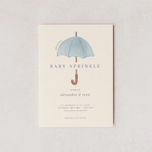Può includere: Biglietto d'invito per baby shower con un'illustrazione di ombrello azzurro. Il testo recita "Baby Sprinkle" e include i dettagli dell'evento, come i nomi "Alexandra & Reed", la data, l'ora e le informazioni RSVP.