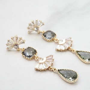 A pair of vintage looking earrings with fan shaped studs and gray stones